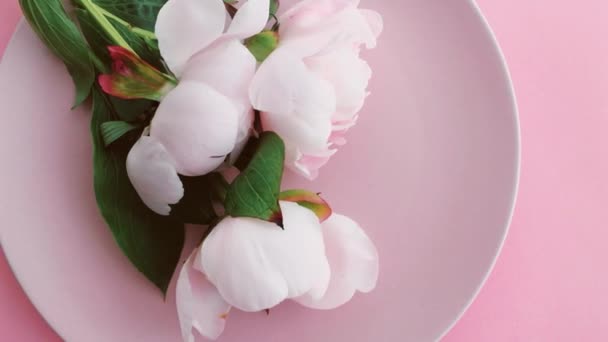 Ροζ τραπεζομάντηλο με παιώνια λουλούδια στο πιάτο και ασημικά για δείπνο πολυτελείας, γαμήλια ή εορταστική εκδήλωση γενεθλίων — Αρχείο Βίντεο