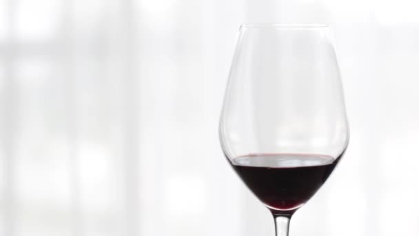 Ποτήρι κόκκινου κρασιού σε εσωτερικούς χώρους σε εκδήλωση γευσιγνωσίας, εορταστικό ποτό και απεριτίφ ως φόντο για την οινολογία και την αμπελοκαλλιέργεια — Αρχείο Βίντεο