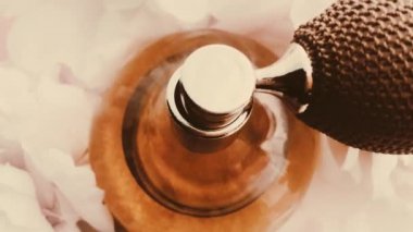 Şakayık çiçekli klasik parfüm şişesi, lüks kozmetik, retro moda ve güzellik ürünleri arka planında şık bir koku.