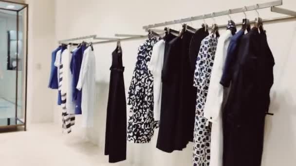 Stilvolle Kleidung in Boutiquen, modernes Ladeninterieur, Luxuseinkäufe und Modekollektion — Stockvideo