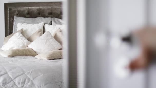 Декоративні подушки та подушки на ліжку в інтер'єрі розкішної спальні, відкриті двері в кімнату, домашній декор та дизайн — стокове відео