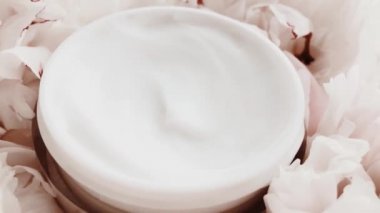 Yaşlanma önleyici yüz kremi kavanozu ve şakayık çiçekleri, lüks kozmetik ürünleri, güzellik ürünleri ve cilt ürünleri için cilt bakım rutini olarak temiz nemlendirici.