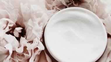 Yaşlanma önleyici yüz kremi kavanozu ve şakayık çiçekleri, lüks kozmetik ürünleri, güzellik ürünleri ve cilt ürünleri için cilt bakım rutini olarak temiz nemlendirici.