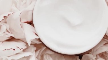 Yaşlanma önleyici yüz kremi kavanozu ve şakayık çiçekleri, lüks kozmetik ürünleri, güzellik ürünleri ve cilt ürünleri için cilt bakım rutini olarak temiz nemlendirici.
