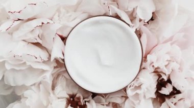 Yaşlanma önleyici yüz kremi kavanozu ve şakayık çiçekleri, lüks kozmetik ürünleri, güzellik ürünleri ve cilt ürünleri için cilt bakım rutini olarak temiz nemlendirici.