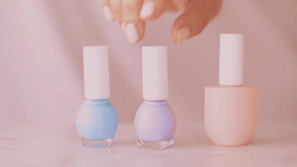 Розовый продукт сцены красоты, женские руки и ногтей бутылки для французского маникюра, красочный пастельный лак для ногтей на мраморном столе, макияж и косметический бренд — стоковое видео