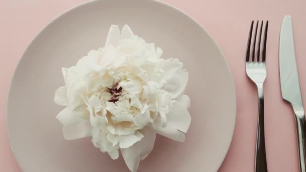 Beige Tischdekoration mit Pfingstrosenblumen auf Teller und Besteck für luxuriöses Dinner, Hochzeit oder Geburtstagsfeier — Stockvideo