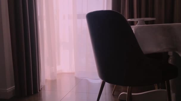 Uitzicht op een eetkamer, ronde tafel, stoelen en raam versierd met gordijnen, meubels en luxe interieur — Stockvideo