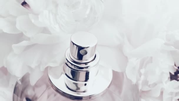 Flacon de parfum blanc avec des fleurs pivoines, parfum chic comme fond cosmétique de luxe, mode et produit de beauté — Video