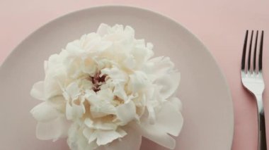 Tabağında şakayık çiçekleri olan bej masa seti ve lüks yemek, düğün ya da doğum günü kutlaması için çatal bıçak takımı.