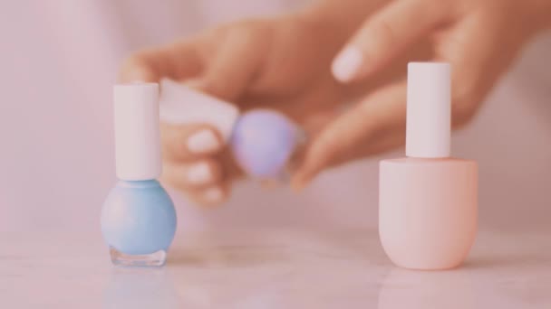 Scène de produits de beauté rose, mains féminines et bouteilles de vernis à ongles pour manucure française, vernis à ongles pastel coloré sur table en marbre, marque de maquillage et cosmétique — Video