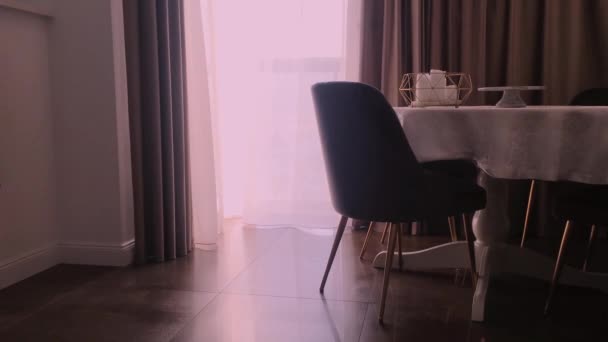 Vista de un comedor, mesa redonda, sillas y ventanas decoradas con cortinas, muebles y diseño de interiores de lujo — Vídeos de Stock
