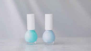 Kadın eli ve tırnak cilası şişeleri, Fransız manikürü için organik kozmetik ürünler mermer masa üzerindeki renkli pastel oje, kız makyajı ve güzellik markası.