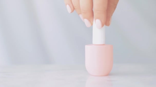 Scène de produits de beauté naturels, mains féminines et bouteilles de vernis à ongles pour manucure française, vernis à ongles pastel coloré sur table en marbre, marque de maquillage et cosmétique — Video