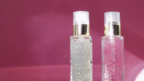 Luxe huidverzorgingsproducten en glanzende lichtflares op roze achtergrond, make-up basis en serum gel als huidverzorgingsroutine voor gezichtscosmetica en beauty merk — Stockvideo