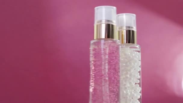 Luxe huidverzorgingsproducten en glanzende lichtflares op roze achtergrond, make-up basis en serum gel als huidverzorgingsroutine voor gezichtscosmetica en beauty merk — Stockvideo