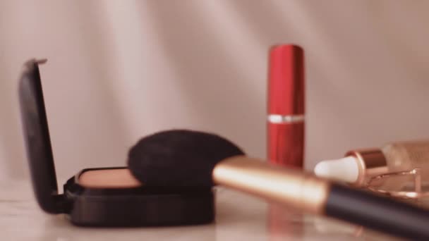 Productos de maquillaje elegantes en mesa de mármol, polvo, lápiz labial y pincel como fondo para la marca de cosméticos y belleza — Vídeos de Stock