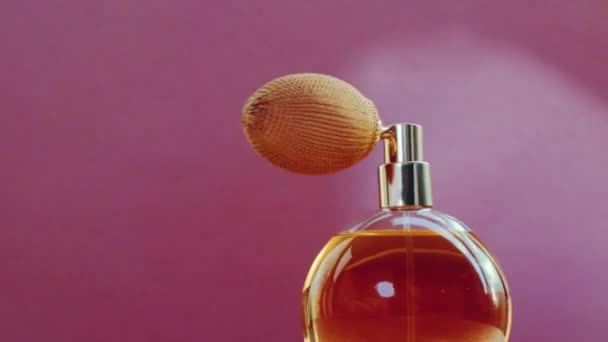 Розкішна золота пляшка парфумів та сяючі спалахи світла на рожевому фоні, гламурний аромат як парфумерний продукт для косметичного та красивого бренду — стокове відео