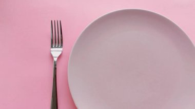 Tabağında şakayık çiçekleri ve lüks yemek, düğün ya da doğum günü kutlaması için çatal bıçak takımı olan pembe masa.