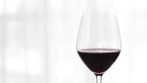 Verre de vin rouge à l'intérieur lors de la dégustation de vin, boisson de vacances et apéritif comme fond pour la marque d'alcool et de spiritueux — Video