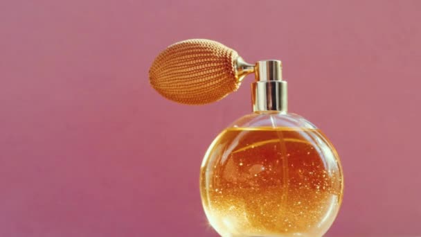 Luxuriöse goldene Parfümflasche und leuchtende Lichterketten auf rosa Hintergrund, glamouröser Duftduft als Parfümerieprodukt für Kosmetik- und Schönheitsmarken