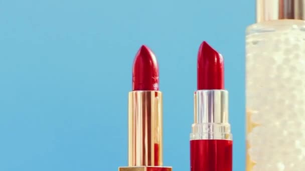 Productos de maquillaje sobre fondo azul, set de cuidado de la piel, perfume y lápiz labial, cosméticos navideños y marca de belleza de lujo — Vídeo de stock