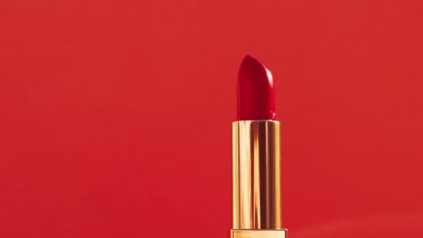 Красная помада в золотой трубке и сияющие световые вспышки, роскошный косметический продукт и праздничная косметика для бренда красоты — стоковое видео