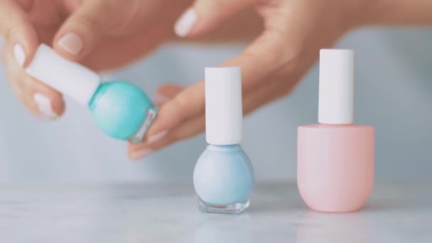 Tangan perempuan dan botol nailpolish, produk kosmetik organik untuk manikur Perancis, cat kuku pastel berwarna-warni di meja marmer, make-up feminin dan merek kecantikan — Stok Video