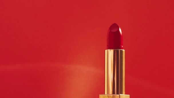 Червона помада в золотій трубці і сяючі спалахи світла, розкішний макіяж і святкова косметика для бренду краси — стокове відео