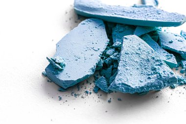 Makyaj paleti olarak mavi far pudrası beyaz arka planda izole edilmiş, ezilmiş kozmetik ve güzellik dokusu