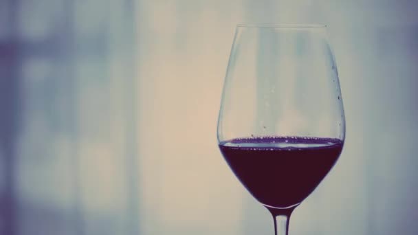 Akşam üstü bir kadeh kırmızı şarap, alkolün ve alkolün arka planı olarak bayram içkisi ve aperatif. — Stok video