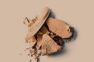 Makyaj paleti olarak bej rengi göz farı kaplaması, ezilmiş kozmetik ürünleri ve güzellik dokusu