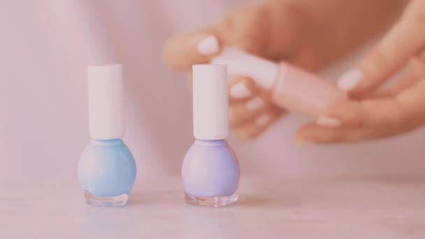 Escena de productos de belleza rosa, manos femeninas y botellas de esmalte de uñas para manicura francesa, esmalte de uñas pastel colorido en mesa de mármol, maquillaje y marca cosmética — Vídeos de Stock