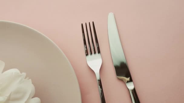 Béžové prostírání stolu s pivoňkovými květy na talíři a příbory pro luxusní večeři, svatbu nebo narozeninovou oslavu — Stock video