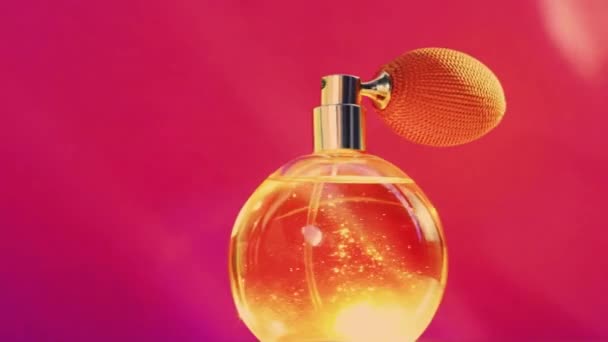 Golden fragrance bottle and shining light flares on pink background, glamorous perfume scent as holiday perfumery product for cosmetic and beauty brand — Stock Video