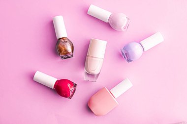 Pembe arka planda oje şişeleri, güzellik markası.