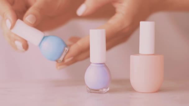 Scena di prodotti di bellezza rosa, mani femminili e bottiglie di smalto per manicure francese, smalto colorato pastello su tavolo di marmo, trucco e marchio cosmetico — Video Stock