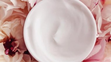 Organik yüz kremi kavanozu ve şakayık çiçekleri, lüks kozmetik ürünleri, güzellik ürünleri ve cilt bakımı için temiz nemlendirici.