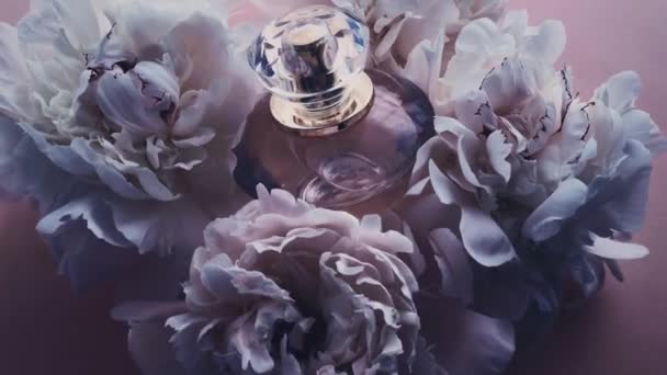 Фіолетова пляшка парфумів з квітами півонії, шикарний аромат аромату як розкішний косметичний, модний і красивий продукт фону — стокове відео