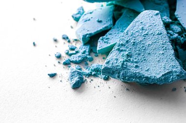 Makyaj paleti olarak mavi far pudrası beyaz arka planda izole edilmiş, ezilmiş kozmetik ve güzellik dokusu