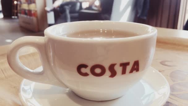 Costa xícara de café de chá quente na mesa no café, cadeia de cafés britânico como editorial ilustrativo — Vídeo de Stock