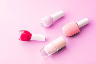 Pembe arka planda oje şişeleri, güzellik markası.