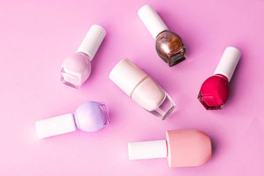 Pembe arka planda oje şişeleri, güzellik markası.