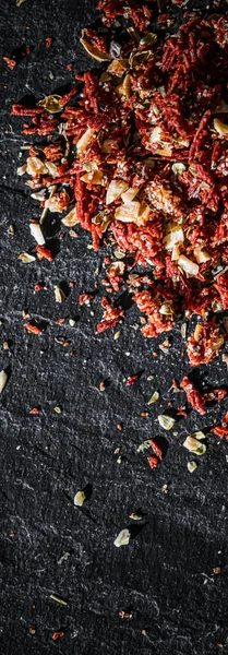 Gedroogde tomaat en chili peper close-up op luxe stenen achtergrond als platte lay, droog voedsel specerijen en recept ingrediënt — Stockfoto