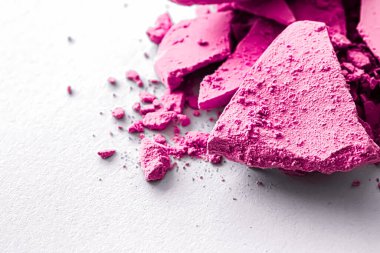 Makyaj paleti olarak pembe göz farı pudrası beyaz arka planda izole edilmiş, ezilmiş kozmetik ve güzellik dokusu