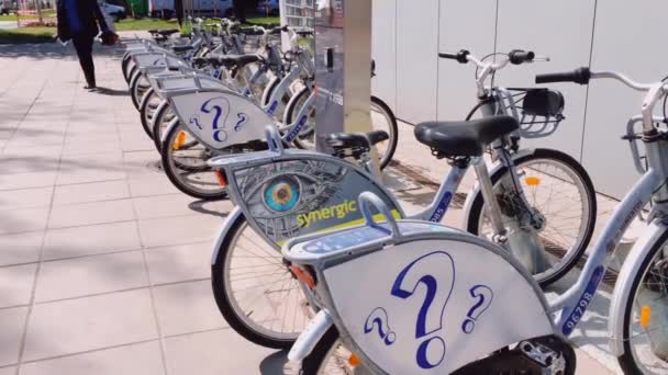 Услуги по обмену велосипедами в европейском городе, велосипеды припаркованы на улице — стоковое видео