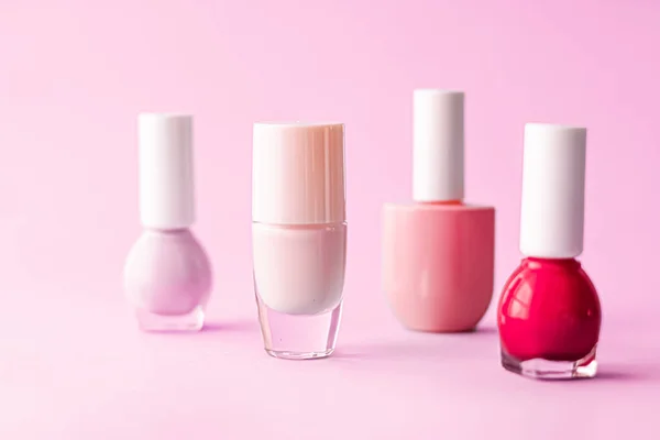 Nail polish bottles on pink background, beauty brand