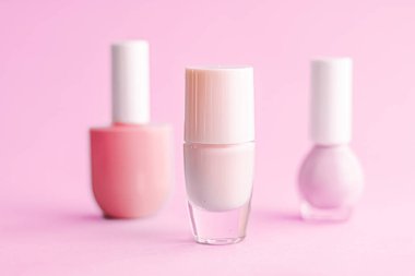 Pembe arka planda oje şişeleri, güzellik markası.