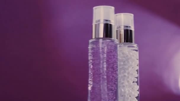 Make-up bas och serum gel som lyx hudvård produkter och glänsande ljus bloss på lila bakgrund, hudvård rutin för ansiktskosmetika och skönhet varumärke — Stockvideo