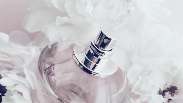 Белая бутылка духов с пионскими цветами, шикарный аромат аромат как роскошный косметический, моды и красоты фона продукта — стоковое видео
